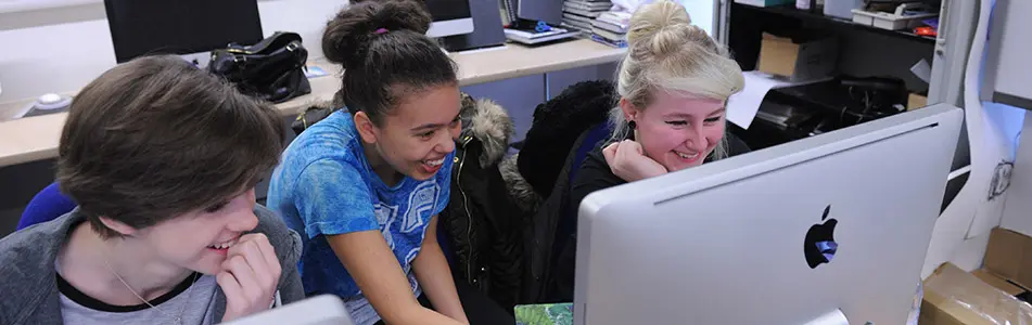 students laughing at the computer screen